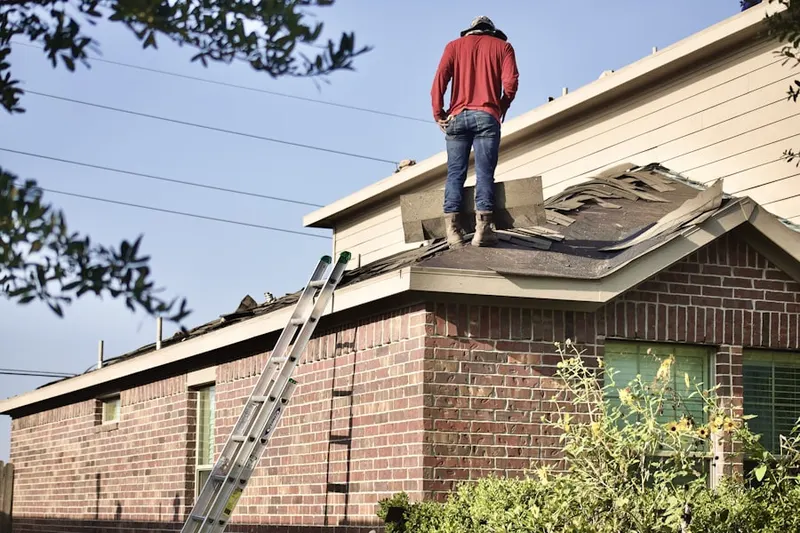 Professional roofer working on a residential roof in West Somerville